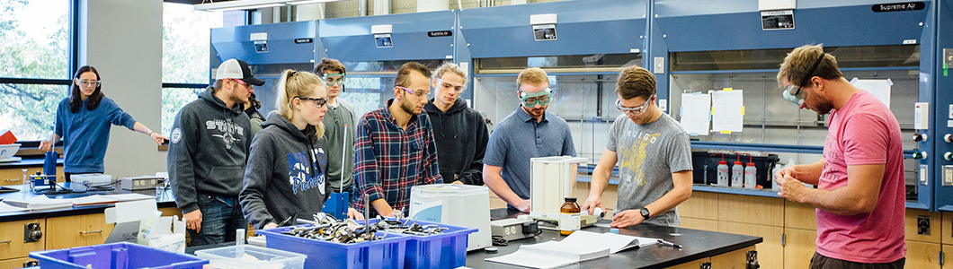 A group of students, one with a particularly excited smile, listen to lesson instructions.