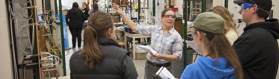 Researcher demonstrates lab equipment to a group of students