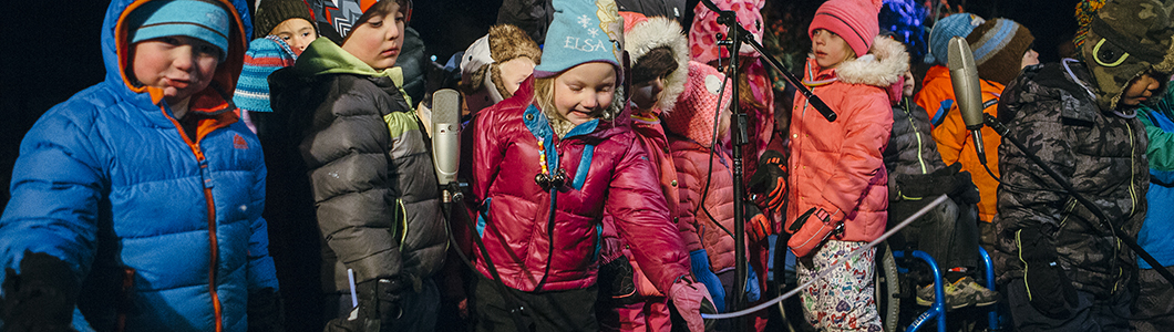 A group of children in winter stand in a line.