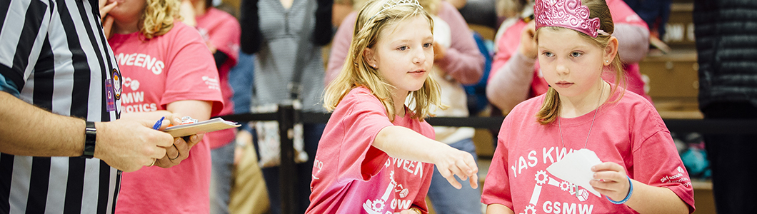 Two students at a robotics competition discuss strategy.