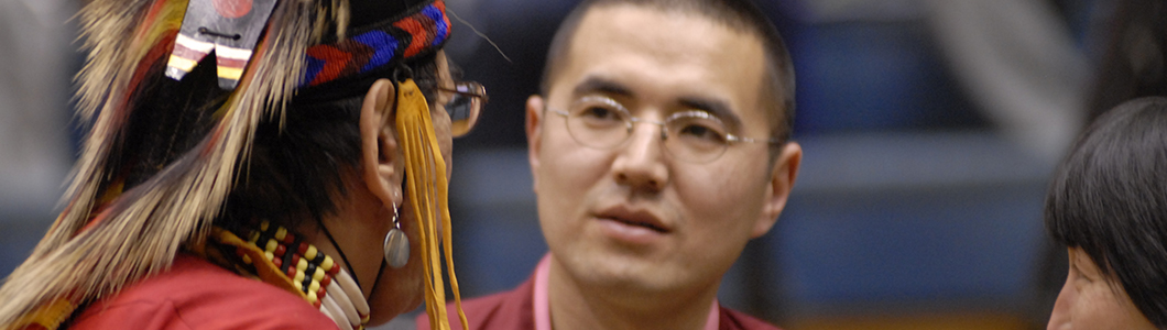 A Buddhist monk looks on as a Native American elder addresses him.