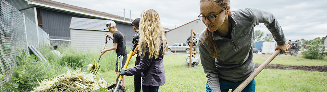 A group of students tend a community garden plot.