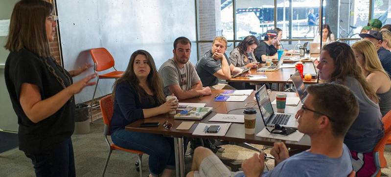 A professor talks to a group of students in the DSEL classroom