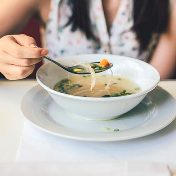 person eating a bowl of soup