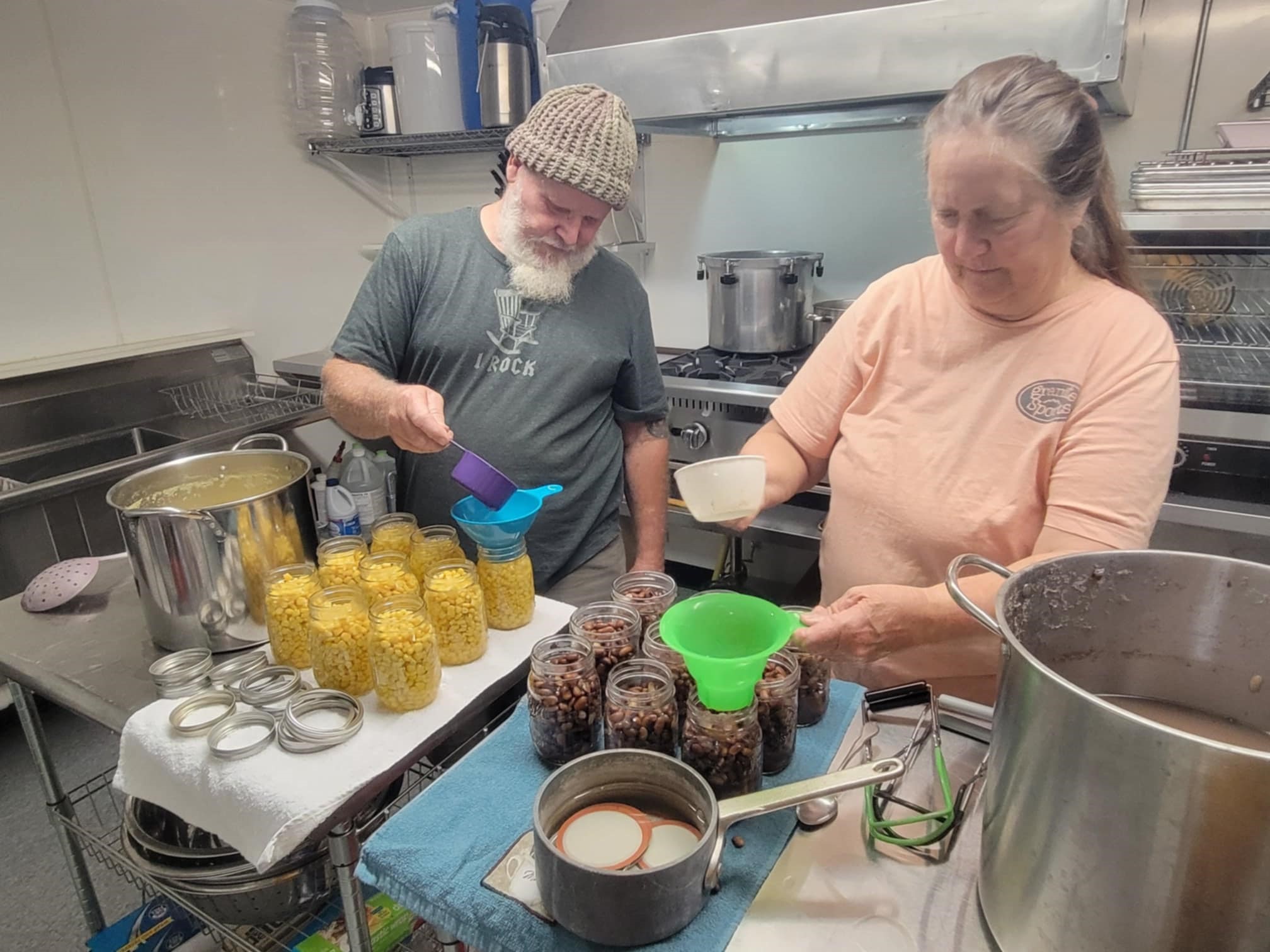 Food preservation students fill jars for canning.