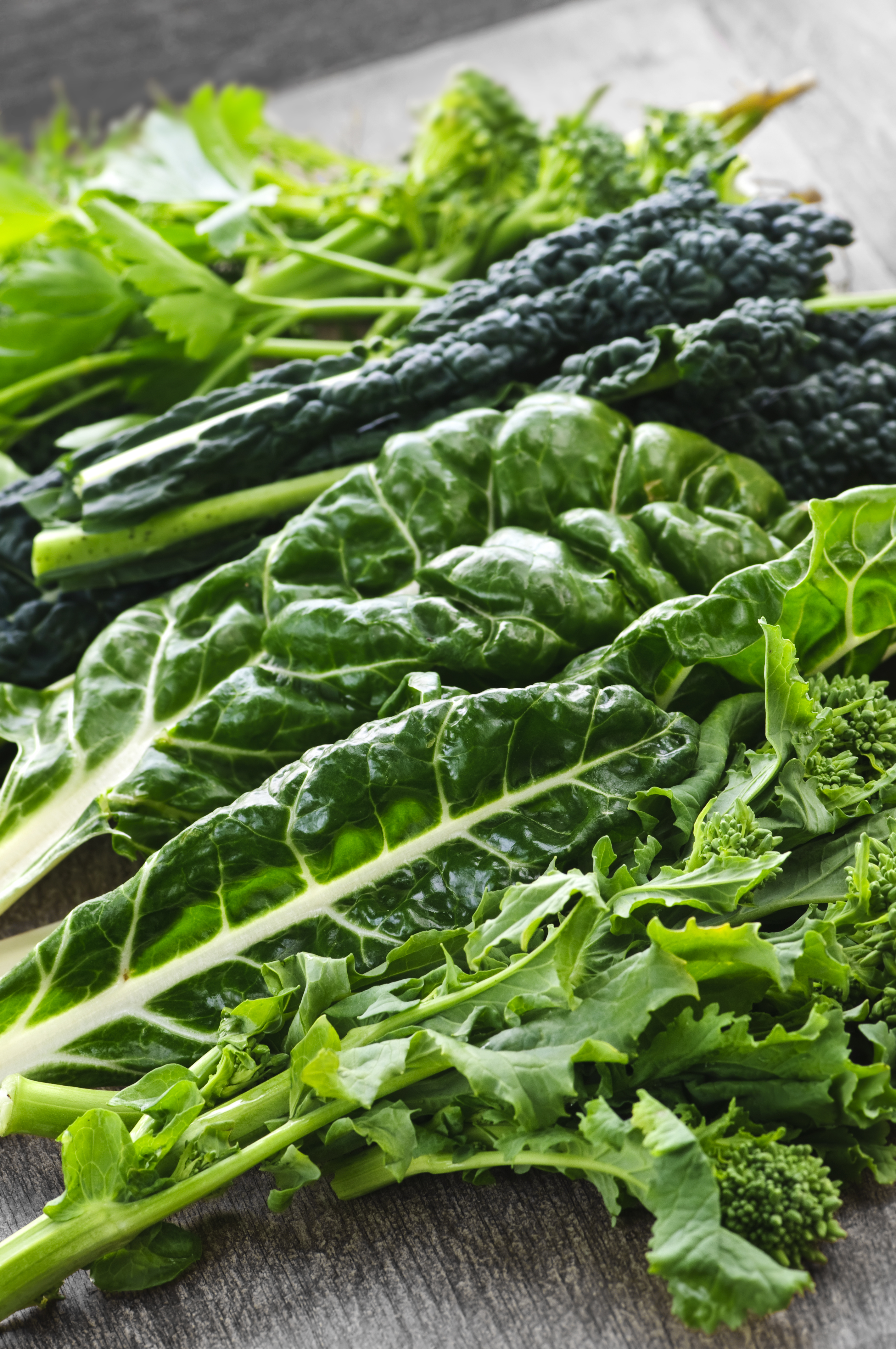 A table with various leafy green vegetables.