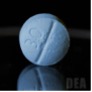 A lab image of a light blue round pill