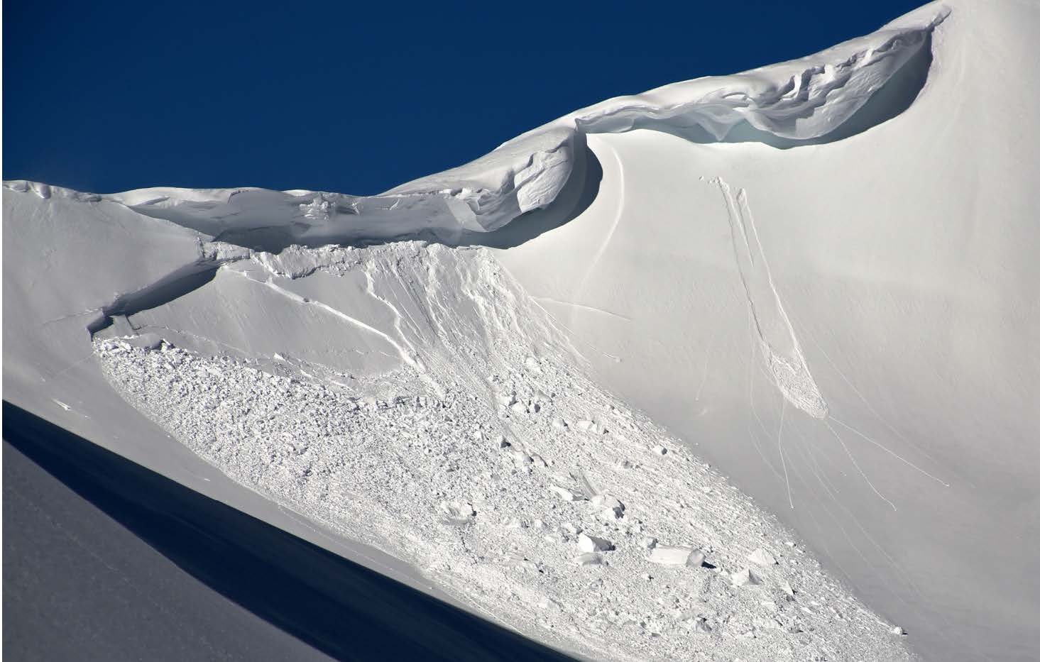 Stark snowcovered mountain ridge with avalanche slide