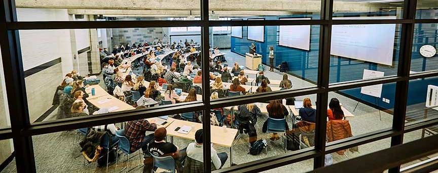 Students and instructor in classroom as seen from outside a window
