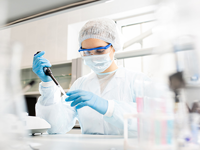 woman pipetting liquid into test tube